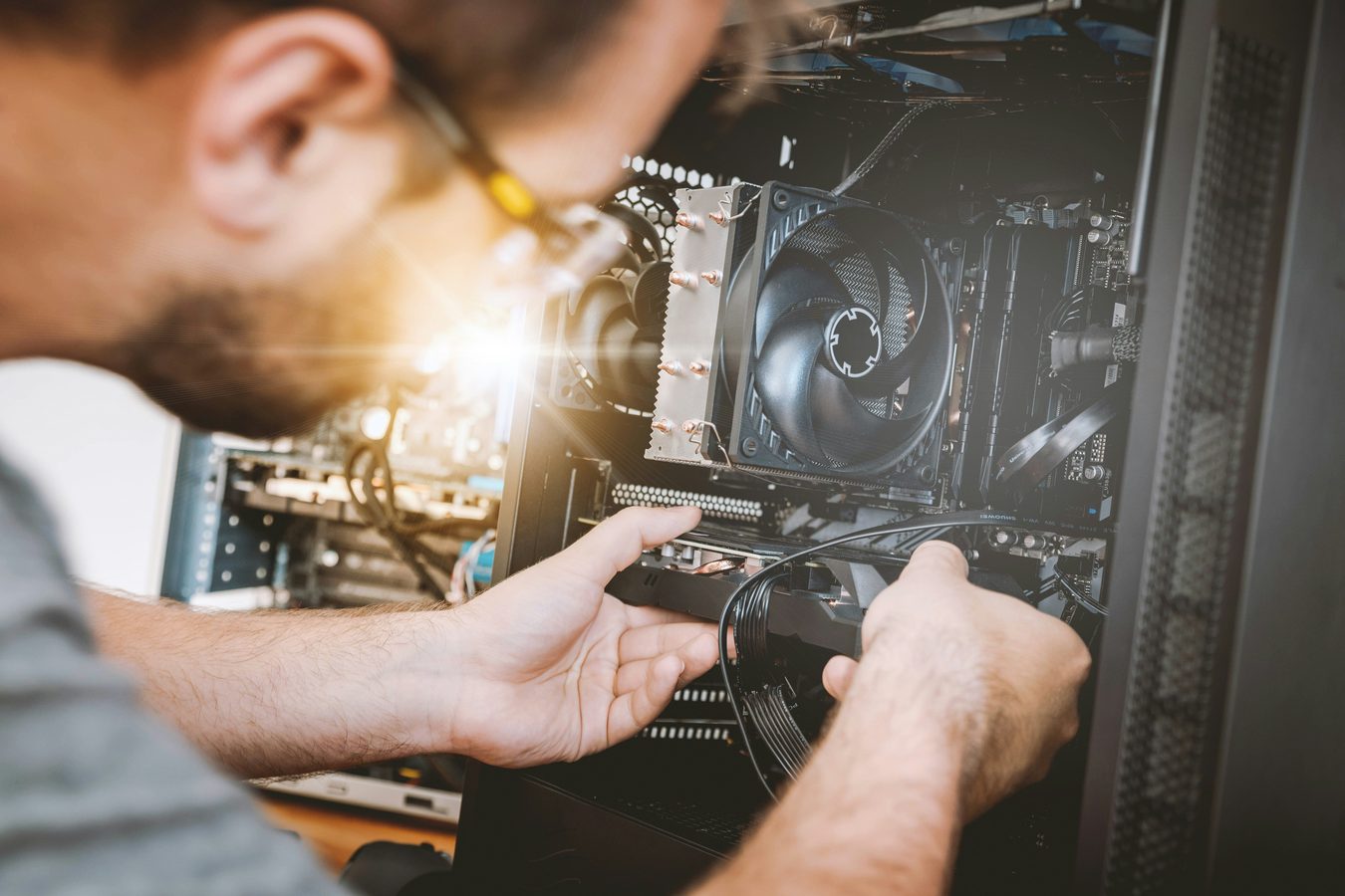 Technician repairing the inside of a desktop computer